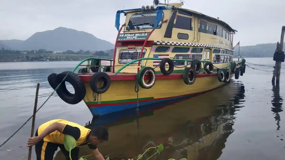 Personel Polsek Balige Gotong Royong Bersihkan Venue F1H20 dari Eceng Gondok 