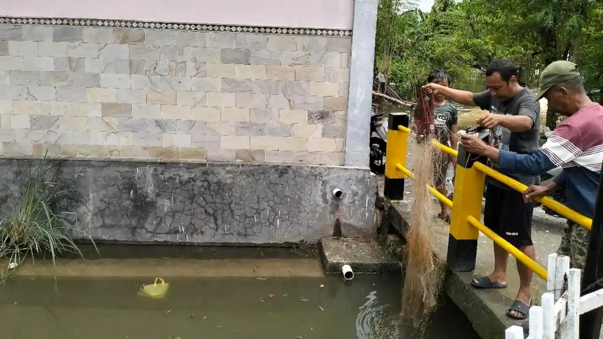 Tak Ambil Pusing, Pria ini Santuy Jaring Ikan di Tengah Banjir Cepu Blora