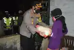 kapolres-pamekasan-akbp-apip-ginanjar-saat-menyerahkan-bantuan-beras-ke-masyarakat.jpg