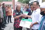 Bupati-menyerahkan-bantuan-bukti-kepesertaan-BPJS-PBI-APBD-Kabupaten-Asahan-Kepada-100-penerima.jpg