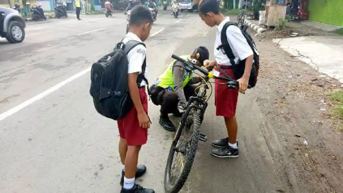Saat Bripda Faridun Niam Bantu Membetulkan Rantai Sepeda Bocah SD