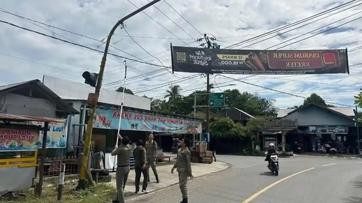 Tegakkan Perbup, Satpol PP HSS Turunkan Spanduk Rokok di Jalan Protokol