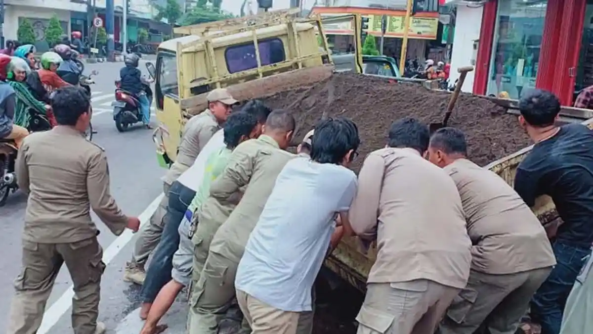 Dump Truk Terperosok Lubang di Jalan Patimura Kediri, Warga Gotong-Royong Mengangkat