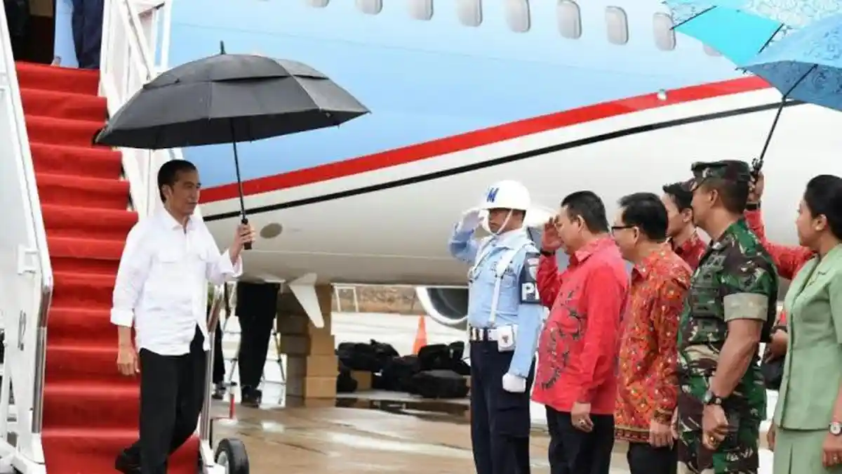 Ditengah Hujan Deras, Jokowi Pegang Payung Sendiri saat Turun dari Pesawat