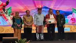 Pj-Bupati-Manggarai-Timur-Boni-Hasudungan-sedang-menerima-penghargaan-Desa-Wisata-Golo-Loni.jpg