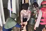 Petugas-polisi-saat-membersihkan-rumah-warga-terdampak-banjir-di-Driyorejo-Gresik.jpg