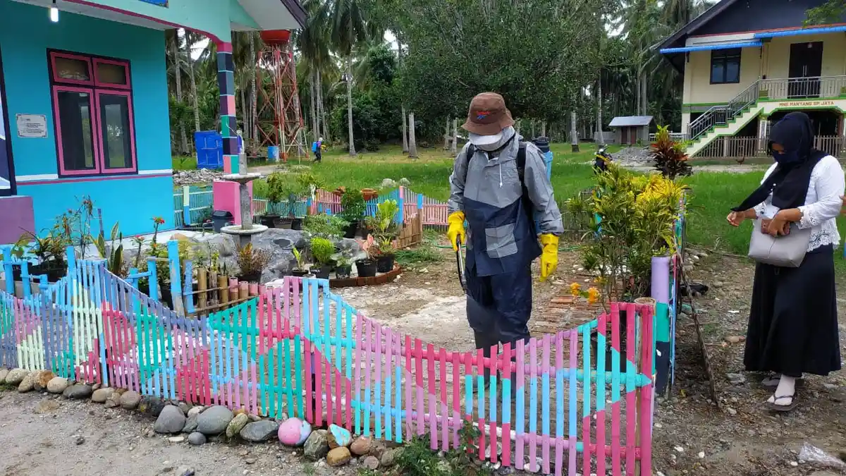 Warga Juli Simpang Jaya Semprot Disinfektan dan Bagi-bagi Masker 