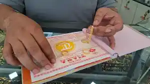 Emas-perhiasan-bentuk-gelang-dan-surat-pembelian-dipegang-pedagang-emas.jpg