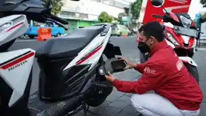 Seorang-mekanik-Honda-Care-memeriksa-komponen-sepeda-motor.jpg