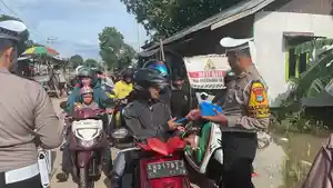Pembagian-jas-hujan-gratis-untuk-jemaah-haul-yang-melintas-di-HSUws.jpg