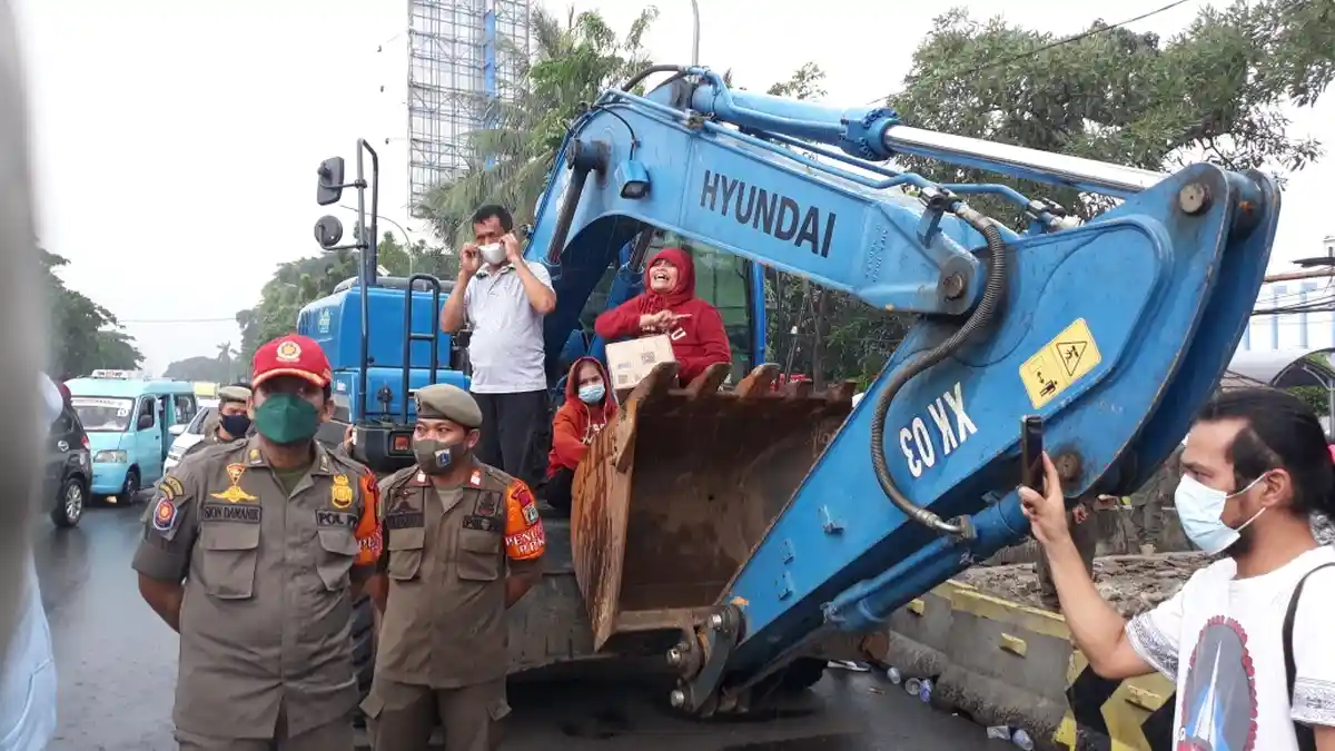 Protes Relokasi, PKL Depan RSU UKI Tidur di Jalan Hingga Duduki Ekskavator