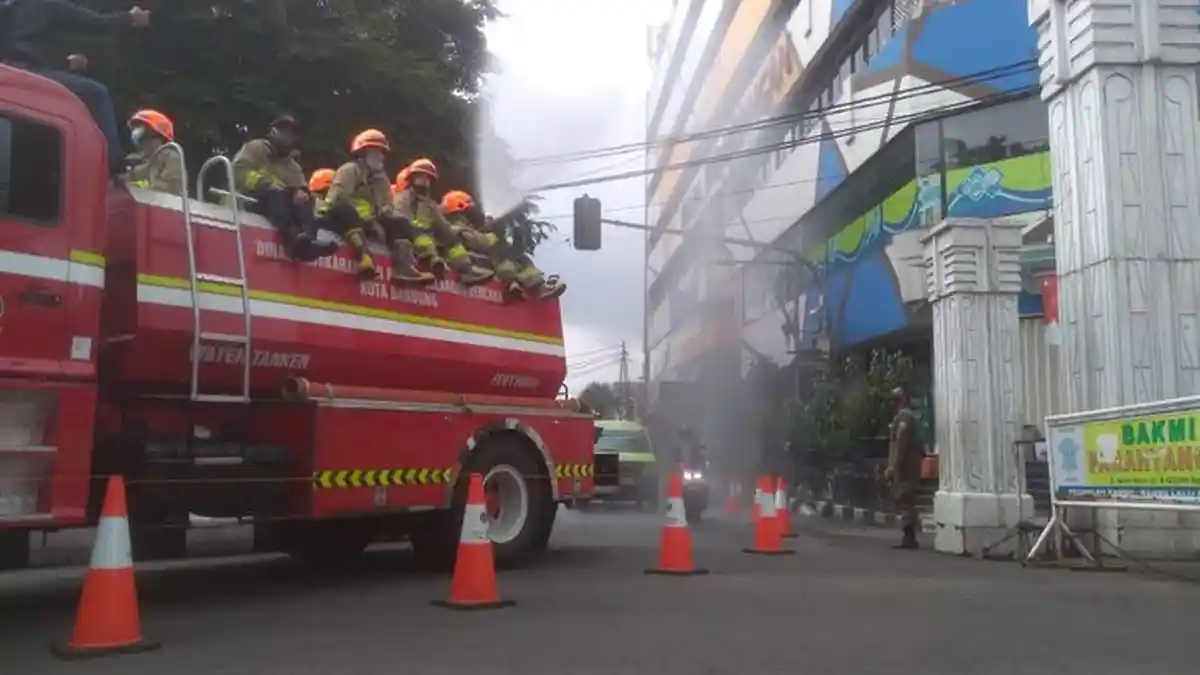 Cegah Penyebaran Covid-19, Mojang Damkar Kota Bandung Semprot Jalanan dengan Disinfektan