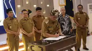 Bupati-Cirebon-Imron-saat-tengah-menandatangani-sebuah-dokumen.jpg