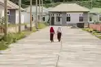 Dua-siswi-SD-berjalan-menyusuri-jalan-yang-tertata-rapi-di-Pemukiman-Baru-Desa-Kawasi-Pulau-Obi.jpg