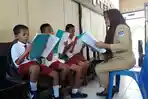 guru-di-sd-tutuyan-sedang-mengajari-muridnya-membaca.jpg