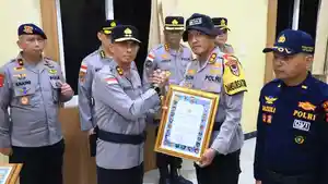 Marzuki-Ali-Basyah-menyerahkan-piagam-penghargaan-kepada-salah-seorang-personel-Polda.jpg