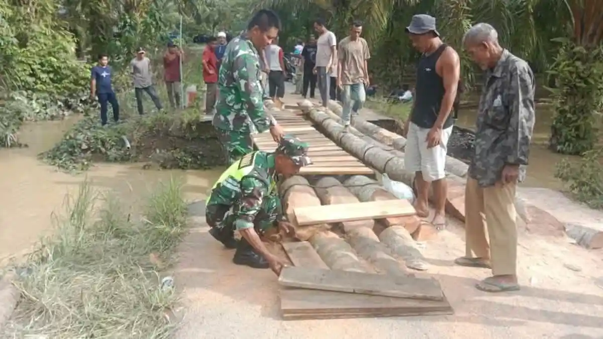 Koramil Darul Makmur Nagan Raya Bantu Bangun Jembatan Darurat di Jalan Putus Diterjang Banjir