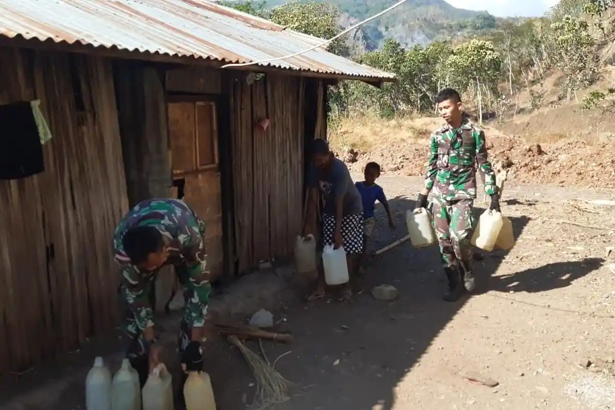 Prajurit TNI Bantu Ambil Air Minum Untuk Warga