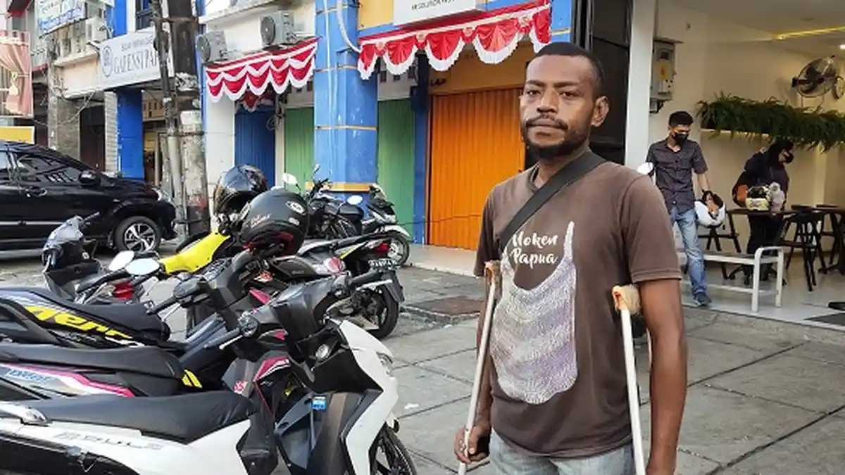 Dua Tongkat Bantu Fredinand Rumaikewi Berdiri Jadi Juru Parkir