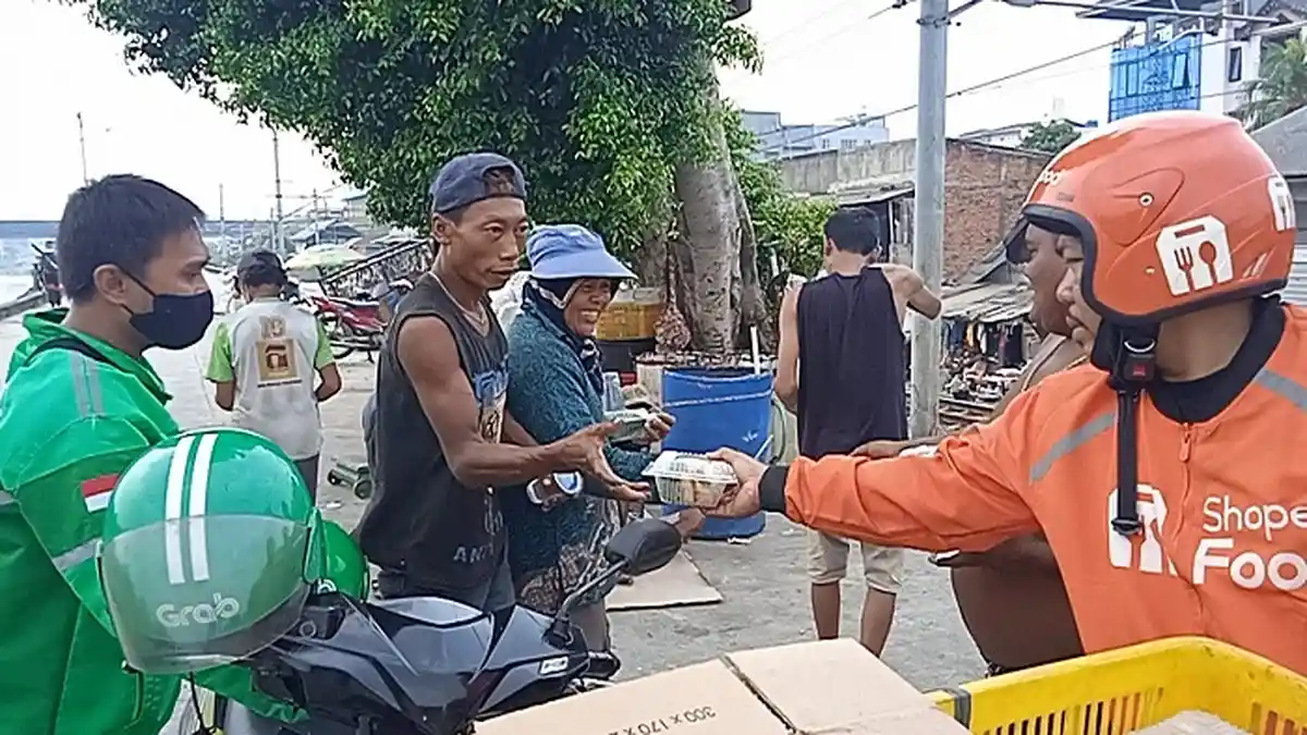 Pengemudi Ojek Online Terpanggil Jadi Relawan Membagikan Nasi Bungkus pada Warga Kurang Mampu