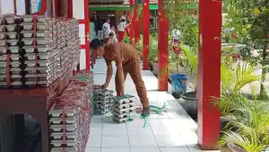 Seorang-guru-menata-ompreng-MBG-di-sebuah-SD-di-Kecamatan-Sumbersari-Jember.jpg