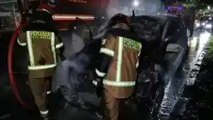 Petugas-pemadam-kebakaran-tampak-melakukan-penyiraman-ke-arah-mobil-yang-terbakar.jpg