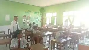 Kepala-SDN-Batu-Cermin-Agustinus-Aba-berdiri-memantau-jalannya-ujian-sekolah.jpg