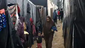 Seorang-wanita-Palestina-dan-seorang-anak-berjalan-di-tengah-hujan.jpg