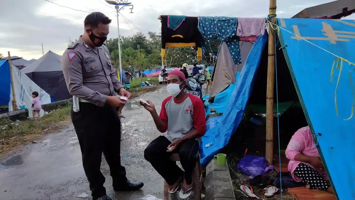 Personel Ditlantas Polda Sulbar Bagi-bagi Masker di Tenda Pengungsian