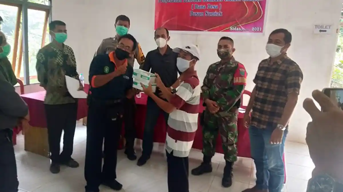Bersama Pihak Kecamatan, Babinsa Serahkan Bantuan Sembako Untuk Warga Isolasi Mandiri