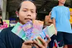 Pemudik-menunjukkan-uang-pecahan-rupiah-yang-telah-ditukarkan.jpg