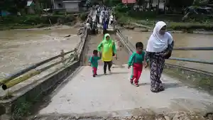 warga-melewati-jembatan-yang-rusak-akibat-banjir-di-solok-selatan-jumat-22112019.jpg