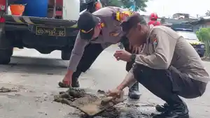 Polsek-Plemahan-melaksanakan-aksi-sosial-berupa-penambalan-jalan-berlubang.jpg