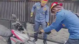 Petugas-damkar-mengevakuasi-ular-yang-masuk-ke-dalam-mesin-motor.jpg
