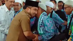 pj-bupati-aceh-besar-menyalami-hamzah-calon-haji-jch-kabupaten-aceh-besar.jpg