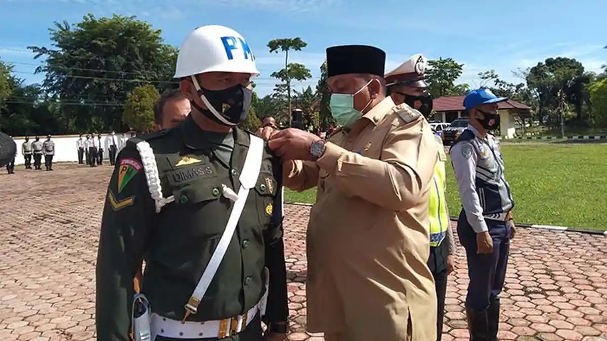 Kala Bupati Aceh Singkil Pasangkan Pita Operasi Patuh Seulawah Ke Anaknya