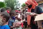 erna-husein-membagikan-makanan-kepada-anak-anak-korban-banjir-di-desa-sirau-kecamatan-kemranjen.jpg