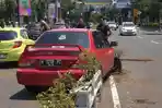 Diduga Direcoki Anak saat Mengemudi, Mitsubishi Lancer Merah Hilang Kendali dan Tabrak Pot Median