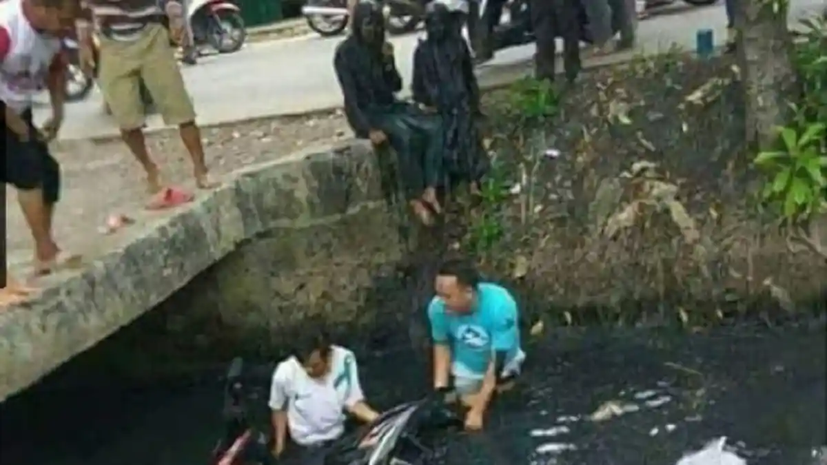Dua Wanita Pengguna Motor Tercebur Got, Netizen Salah Fokus ke Sosok Hitam Ini