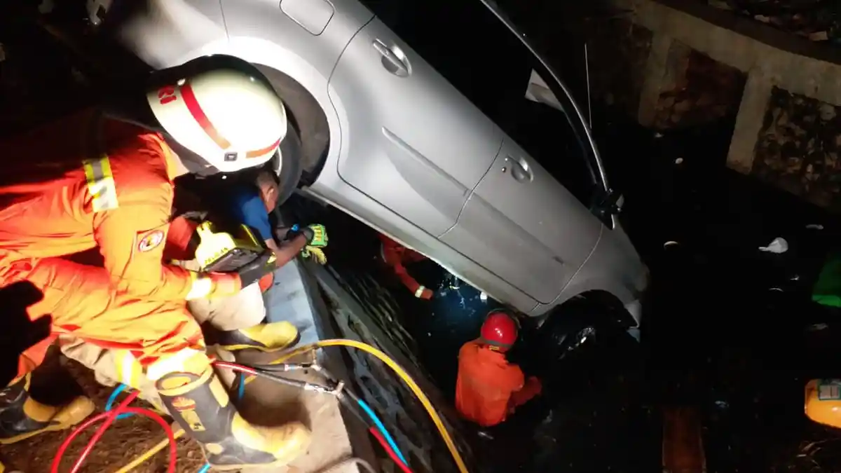 Hindari Tabrakan, Mobil Xenia Terperosok ke Kali Jalan Pulo Mas