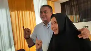 Rudy-Susmanto-baju-biru-bersama-istri-jilbab-hitam-menggunakan-hak-pilih.jpg