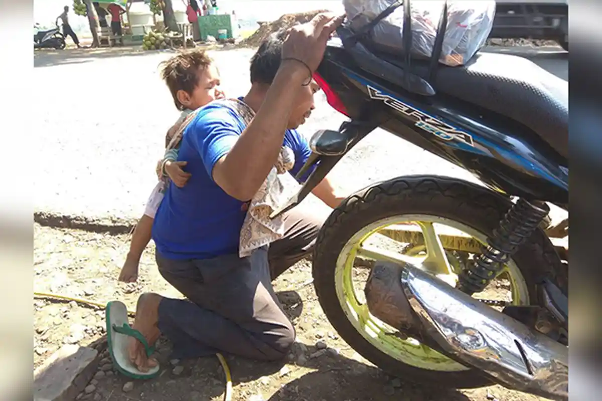 Ditinggal Mati Sang Istri, Tukang Tambal Ban di Cianjur Layani Pelanggan Sambil Gendong Anak