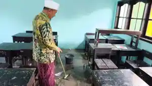 Ketua-Yayasan-MI-NW-Leneng-Praya-menunjuk-bekas-genangan-air-di-ruang-kelas.jpg