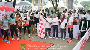 Sekretaris-Daerah-Kabupaten-Tapin-H-Sufiansyah-mengibarkan-bendera-start-AGM-Fun-Run-2024.jpg