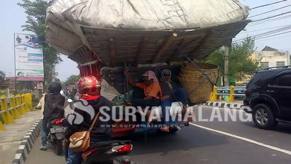 Dua Pekerja ini Menantang Maut dengan Bergelantungan di Truk