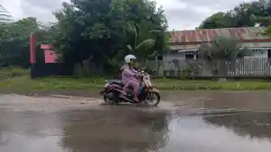 Pengendara-yang-melintasi-jalan-yang-tergenang-air-di-Jl-H-Abd-Malik-Pettanna-Endeng.jpg
