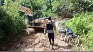 Seorang-polisi-berjalan-menuju-ke-arah-alat-berat-yang-sedang-membersihkan-material-longsor.jpg