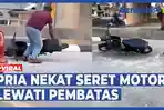 VIDEO - Pria Nekat Seret Motor Lewati Portal Pembatas, Ditegur tapi hanya Balas Senyuman