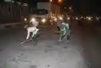 Kuli Bersihkan Ceceran Tanah di Jalan Daan Mogot
