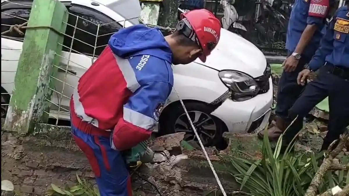 Mobil Tertimpa Pagar Roboh Saat Hujan Deras di Kota Jambi Dini Hari Tadi
